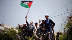 Palestinci v Gaze vylezli na strom během shromáždění konaného u příležitosti Svátku práce.