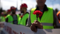 Člen řeckých odborů PAME drží v ruce karafiát během prvomájové manifestace v Aténách.