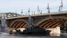 Vyzvednutí vraku potopené výletní lodi komplikuje zvýšená hladina Dunaje. Na Markétině mostě visí černé prapory, které připomínají neštěstí, př němž zemřelo 7 lidí a 21 se pohřešuje.
