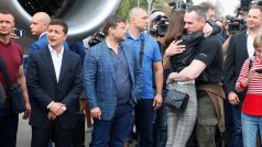 Ukrajinský prezident Volodomyr Zelenskyj (vlevo) přihlíží návratu vězňů z Ruska. Mezi nimi přiletěl i režisér Oleg Sencov (uprostřed).