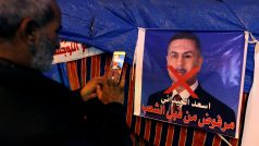 Demonstrant u plakátu, na němž je guvernér Basry a kandidát na premiéra Asaad Ajdání. Toho protestující odmítají