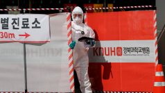 Zdravotní pracovník u brány místa testování na koronavirus v jihokorejském městě Tegu