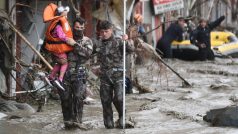 Záchranná jednotka po prohledávání zničených domů ve městě Bozkurt evakuuje dítě.