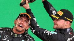 Lewis Hamilton slaví vítězství na Velké ceně Brazílie, kde ho na stupních vítězů polévá šampaňským v cíli třetí  Valtteri Bottas