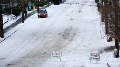 Auto pomalu sjíždí z kopce na uzavřené Queen Anne Avenue North, po silném sněžení v Seattlu.