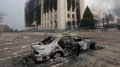Shořelé auto před budovou radnice v kazašském Almaty, která byla během protestů zapálena