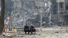 Obyvatelé obklíčeného Mariupolu před vybombardovanými budovami