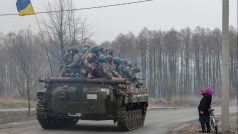 Žena salutuje bojovému vozidlu pěchoty vezoucímu ukrajinské vojáky u Černihivu