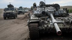 Ukrajinské síly projíždějící okolo zničeného ruského tanku v blízkosti Izjumu