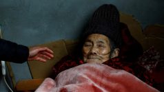 Muž se stará o svou 86letou matku, která je na kyslíku. Vrátila se domů z nemocnice ve vesnici v provincii S’-čchuan