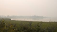 Nad jezerem u města Yellowknife se vznáší kouř z nedalekého požáru