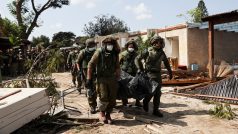 Vojáci odnáší těla obětí v kibucu Kfar Aza, kde podle zpravodajského webu The Times of Israel Hamás v sobotu zavraždil 70 izraelských civilistů.