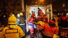 Zdravotníci převážejí obyvatele Kyjeva, který byl zraněný během ruského raketového útoku