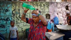 Žena si lije vodu na hlavu při teplém dni v Novém Dillí