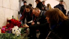 Lidé po útoku u stanice metra pokládají květiny a zapalují svíčky.