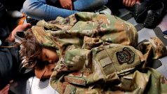 Afghánské dítě spí na podlaze amerického armádního letadla pod uniformou letce během evakuačního letu z afghánského Kábulu
