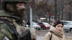 Obyvatelka Almaty prochází kolem ruského vojáka, zástupce „mírových jednotek“ Organizace Smlouvy o kolektivní bezpečnosti