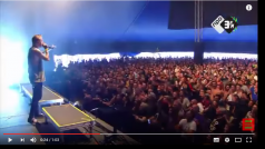 Scéna z koncertu kapely Architects. Zpěvák Sam Carter před publikem