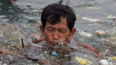 Muž plave v hromadě plastů kumulujících se v moři