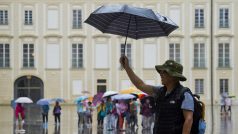 Turisté za deštivého počasí 29. června na třetím nádvoří Pražského hradu.