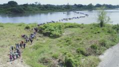 Migranti zejména ze Salvadoru překračující mělkou část hraniční řeky mezi Mexikem a Guatemalou