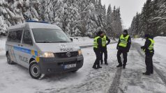 Policisté hlídkují u abertamské křižovatky nad Jáchymovem, kde silničáři uzavřeli sněhem zavátou silnici směrem na Boží Dar