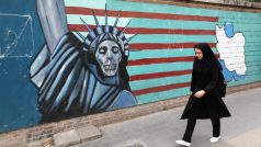 Íránka kráčí podél výmluvné nástěnné malby na zdi, která obklopuje areál bývalé americké ambasády v Teheránu (8. května 2018).