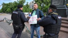 Policisté zadržují demonstranta s plakátem, na kterém je napsáno „všechno nejlepší k narozeninám Alexeji“ v Moskvě