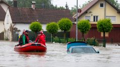 Záchranáři ve městě Babenhausen projíždějí zaplavenou ulicí v nafukovacím člunu