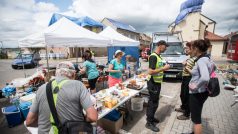 Úklid, obnova a demolice v obci Hrušky týden po zpustošení tornádem. Stánek dobrovolníků.