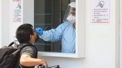 Obyvatel Tchaj-wanu podstupuje antigenní test ve stánku u letiště v Tchaj-peji
