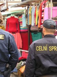 Pracovníci policie a celní správy při kontrole tržnice