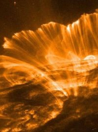 Rotující nabité částice září kolem siločar vystupujících ze slunečního povrchu.
