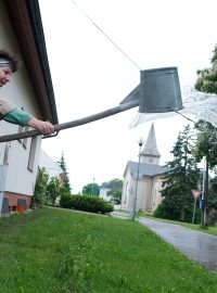 Paní Vilma ručně odčerpává vodu ze svého domu. Povodně z roku 1997 má ještě v živé paměti, ale kvůli své mamince na Troubky nezanevřela