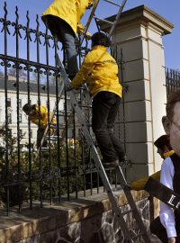 Aktivisté Greenpeace lezou přes plot Strakovy akademie