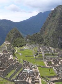 Machu Picchu (kečujsky Stará hora) s branou na inckou stezku za zády, uprostřed posvátné místo, v pozadí Wayna Picchu (kečujsky Mladá hora)