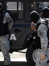 Policisté eskortují jednoho z podezřelých z vraždy pěti lidí nedaleko makedonské metropole Skopje