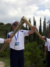 Spyridon Janniotis (L), řecký plavec, Alexander Loukos (R), britský boxer, si předávají olympijské světlo v řecké olympii. Olympijská pochodeň poputuje do Velké Británie