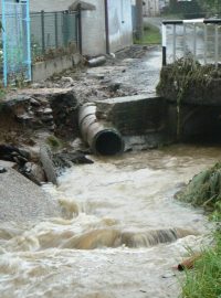 Poškozená silnice a zahrada domu v Kocourově