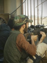 Ozbrojený člen Syrské osvobozenecké armády brání dům v Homsu