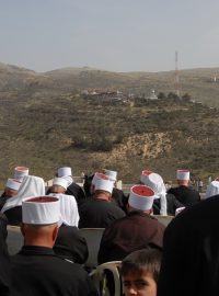 Účastníci každoročního jarního setkání Drúzů hledí z Izraelem okupovaných Golan na bratry na tribuně v Sýrii