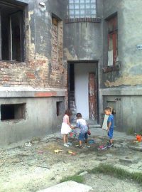 Děti před domem v lokalitě přednádraží, kde začala téct voda.jpg