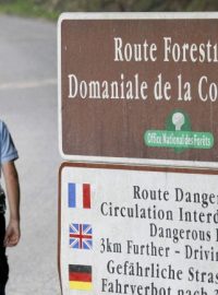 Francouzský četník hlídá cestu do oblasti poblíž Annecy, kde byli v autě nalezeni čtyři zastřelení lidé