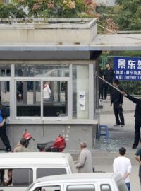 Dělníci čínské továrny Foxconn uklízejí rozbité sklo po noční potyčce