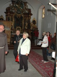 Františkán Antonín Klaret Dąbrowski ukazuje kapli, v níž je pohřbeno čtrnáct pražských mučedníků