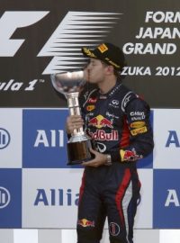 Sebastian Vettel líbá trofej pro vítěze Velké ceny Japonska, vedle něj stojí druhý Massa (vlevo) a třetí Kobajaši