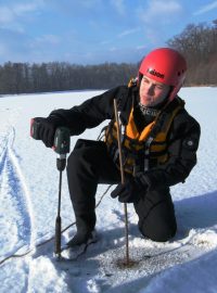 Policista Martin Racek měří tloušťku ledu na Zámeckém rybníku v Chlumci na Ústecku