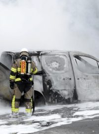 Hasiči likvidují požár auta na předměstí Stockholmu
