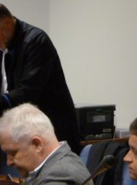V popředí uprostřed obžalovaný Roman Vaškůj, v pozadí advokát Tomáš Sokol