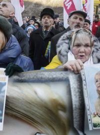 Protestující drží portréty uvězněné expremiérky Tymošenkové na proevropské demonstraci v Kyjevě